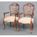 A pair of 19th Century Dutch mahogany slat back open arm chairs, the seats of serpentine outline