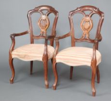 A pair of 19th Century Dutch mahogany slat back open arm chairs, the seats of serpentine outline