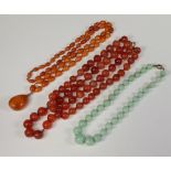 An amber graduated oval bead necklace 86cm, an agate ditto 44cm and a green hardstone bead