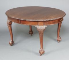 A 1930's Chippendale style oval extending dining table with gadrooned border, raised on cabriole