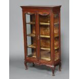 An Edwardian mahogany display cabinet with plush shelved interior, enclosed by glazed panelled