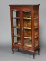 An Edwardian mahogany display cabinet with plush shelved interior, enclosed by glazed panelled