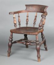 A 19th Century elm smoker's bow armchair with solid seat and bobbin turned decoration, double H