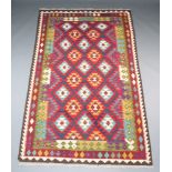 A red, green, blue and white ground Maimana Kilim rug with all over diamond design 251cm x 153cm