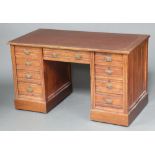 A Victorian oak desk with brown inset writing surface above 1 long and 8 short drawers with brass