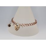 A yellow metal 9ct bracelet with charm and heart padlock 15.4 grams