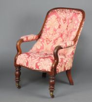 A Victorian mahogany show frame open arm chair upholstered pink floral buttoned material, raised