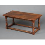 A rectangular oak coffee table raised on turned and block supports with box framed stretcher 45cm