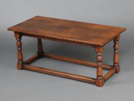 A rectangular oak coffee table raised on turned and block supports with box framed stretcher 45cm