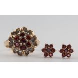 A yellow metal garnet set ring size L 1/2 and a pair of ditto ear studs 5.6 grams