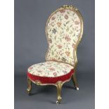 A Victorian gilt painted show frame nursing chair upholstered in tapestry material raised on