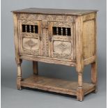 A reproduction 17th Century Ipswich style carved hutch cabinet enclosed by a panelled door with