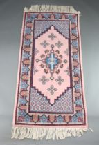 A pink and blue ground Afghan rug with stylised medallions to the centre 207cm x 100cm