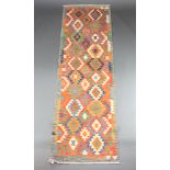 A yellow, green and brown ground Chobi Kilim runner with geometric designs 284cm x 86cm