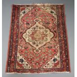 An Afghan red and white ground rug with central medallion 140cm x 107cm In wear