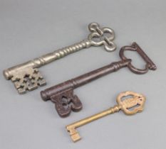 Two large church style door keys 25cm and a Continental gilt metal key decorated a coat of arms 17cm