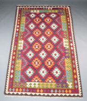 A red, green, blue and white ground Maimana Kilim rug with all over diamond design 251cm x 153cm