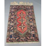 A pink, blue and green ground Afghan rug with 3 stylised medallions to the centre 191cm x 120cm In