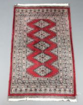 A red and white ground Bokhara rug with 5 diamonds to the centre 136cm x 80cmWear to the binding