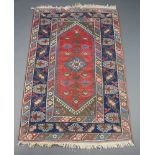 A Persian brown, blue and white rug with central medallion within a multi row border 194cm x 122cm