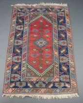 A Persian brown, blue and white rug with central medallion within a multi row border 194cm x 122cm