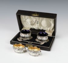 A pair of silver table salts with repousse decoration Sheffield 1901 together with a pair of