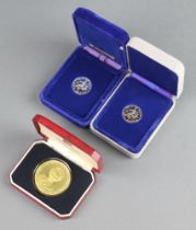 Two silver Isle of Man one pound coins together with a plated commemorative crown Margaret