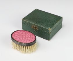 An Edwardian oval child's hairbrush with pink guilloche decoration cased, Birmingham 1902