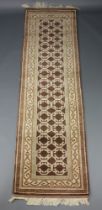 A brown and white ground machine made runner with geometric design 293cm x 82cm Some staining to the