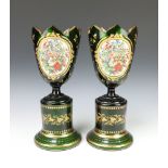 A pair of 19th Century Bohemian green glass vases decorated with panels of scrolling spring flowers,