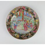 An 18th Century Chinese famille rose plate decorated with figures on a pavilion terrace enclosed