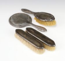 A silver hand mirror Birmingham 1916, a pair of clothes brushes and a hair brush, different makers