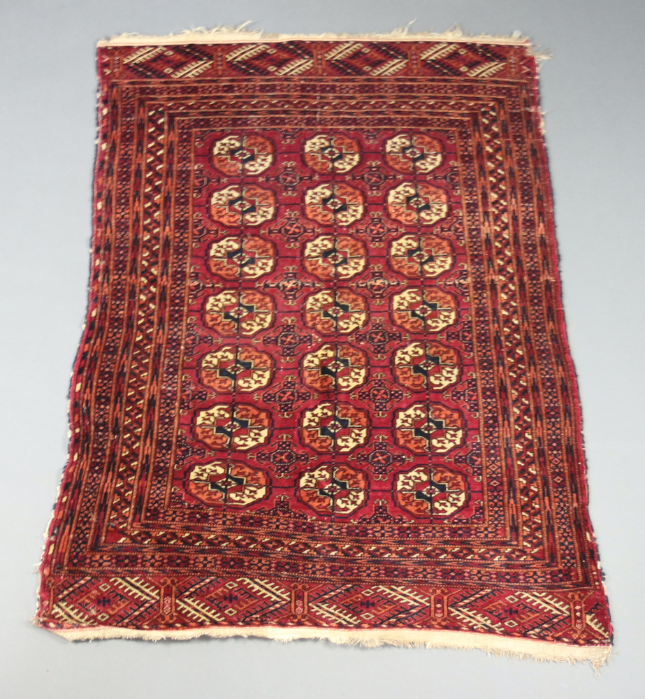 A red and blue ground Bokhara rug with 21 octagons to the centre 150cm x 107cm In wear and signs