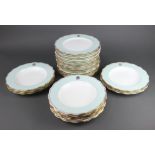 Eighteen Victorian dinner plates with turquoise and gilt rims and monogram, signed by W P and G