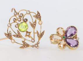 An Edwardian yellow metal amethyst, emerald and topaz pansy brooch, a peridot and seed pearl ditto