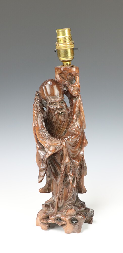 A Chinese pierced and carved hardwood figure of a standing Deity converted to a table lamp 30cm h