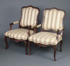 A pair of French style mahogany show frame open arm chairs, the seats and backs upholstered in