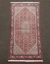 A blue, white and red ground Bijar rug with diamond shaped medallion to the centre 137cm x 67cm
