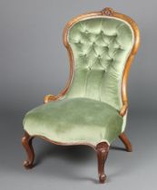 A Victorian bleached mahogany show frame nursing chair upholstered in green buttoned material raised