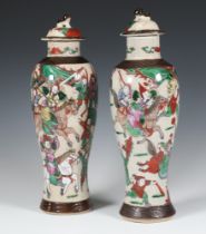 A pair of Chinese crackle glazed oviform vases and covers decorated with warriors 32cm Both have