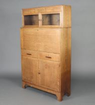Minty, a 1930's Art Deco oak students bureau, the upper section enclosed by a panelled door above