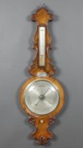 A Victorian mercury barometer and thermometer with silvered dial contained in a carved walnut case