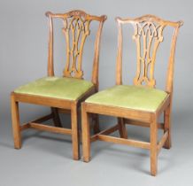 A pair of Chippendale style dining chairs with pierced vase shaped slat backs and upholstered drop