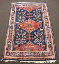 A blue and floral ground Persian rug with central medallion, having an animal motif within a multi
