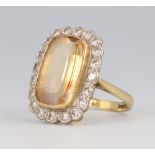 An 18ct yellow gold citrine and diamond cluster ring, the centre stone approx. 15mm x 10mm, the 20
