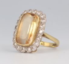 An 18ct yellow gold citrine and diamond cluster ring, the centre stone approx. 15mm x 10mm, the 20