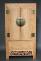 A 19th Century Chinese bleached hardwood cabinet enclosed by a pair of panelled doors with