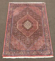 A red, white and blue Bijar rug with diamond shaped central medallion 180cm x 112cm, signed VDH to