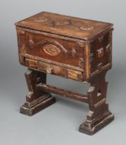 A 17th Century style miniature oak coffer with hinged lid revealing a plush interior, the base