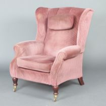 A Parkerknoll Victorian style winged armchair upholstered in pink material, raised on turned